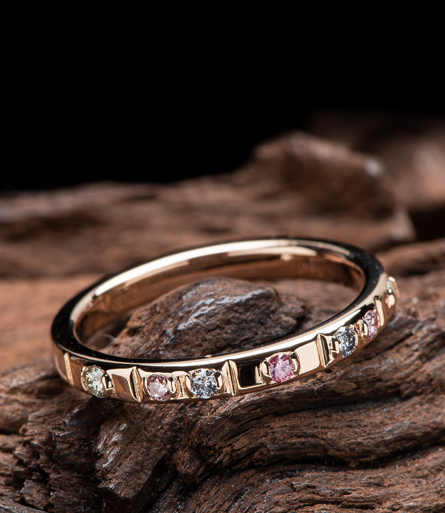 ブルー、ピンク、透明色のダイヤを並べたピンクゴールド素材のリング
